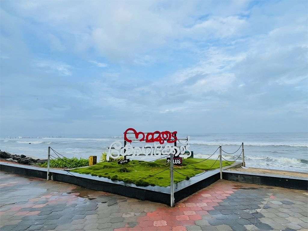 Kozhikode beach promenade with the city name sculpture in Malayalam, looking out to the Arabian Sea