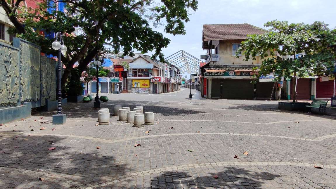 SM Street, Kozhikode: the paved pedestrian retail spine with shuttered shopfronts, bollards and street lamps, looking down the length of the street